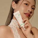 Model holding OTC version Complete No-Stress Physical Sunscreen V.3, highlighting its skin-enhancing benefits and lightweight formula for a radiant complexion.